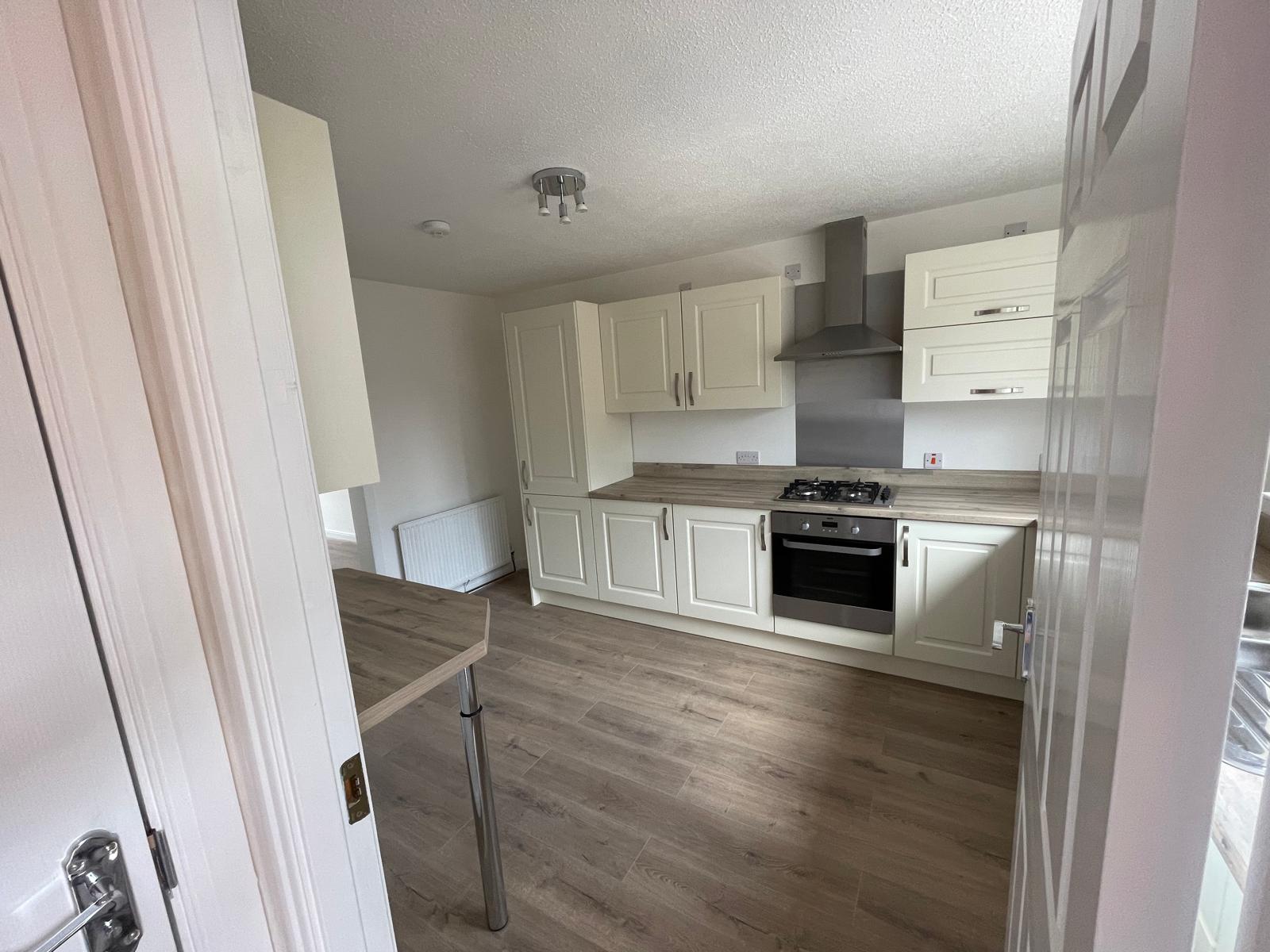 Cream shaker kitchen with laminate flooring