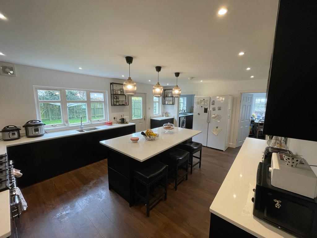 Black kitchen with white quartz island and pendants