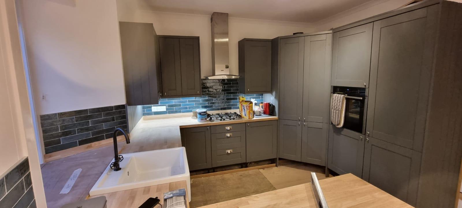 Dark shaker kitchen with blue tile splashback