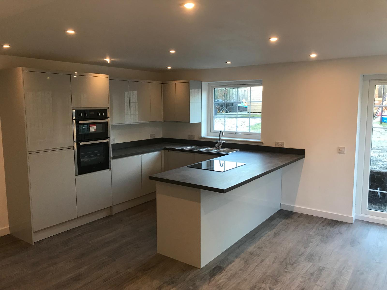 U-shaped gloss kitchen with dark worktops