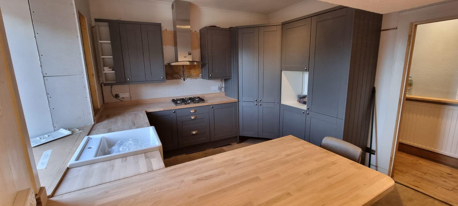Blue-grey shaker kitchen during installation