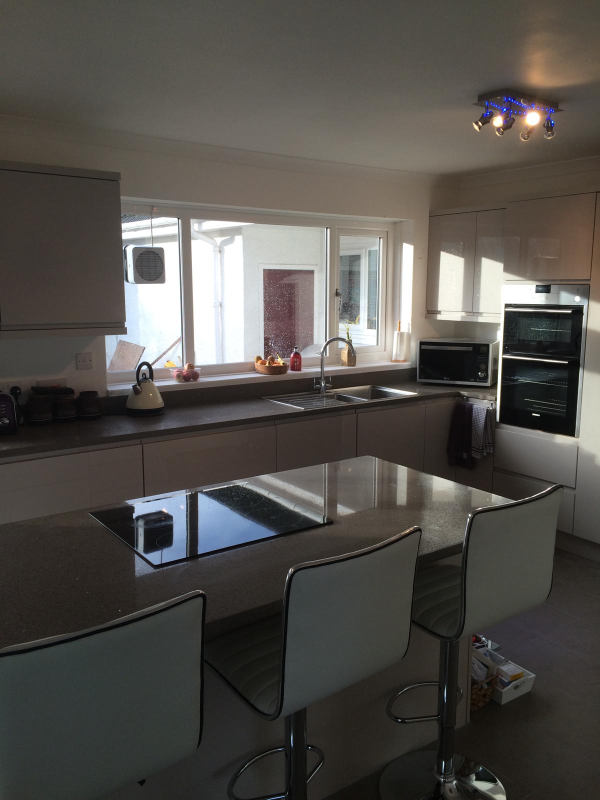 Modern kitchen with bar stools and dark worktops