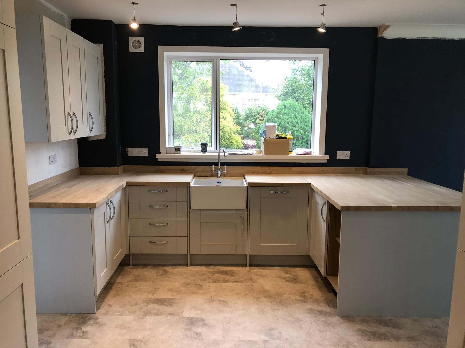 U-shaped cream kitchen with navy walls