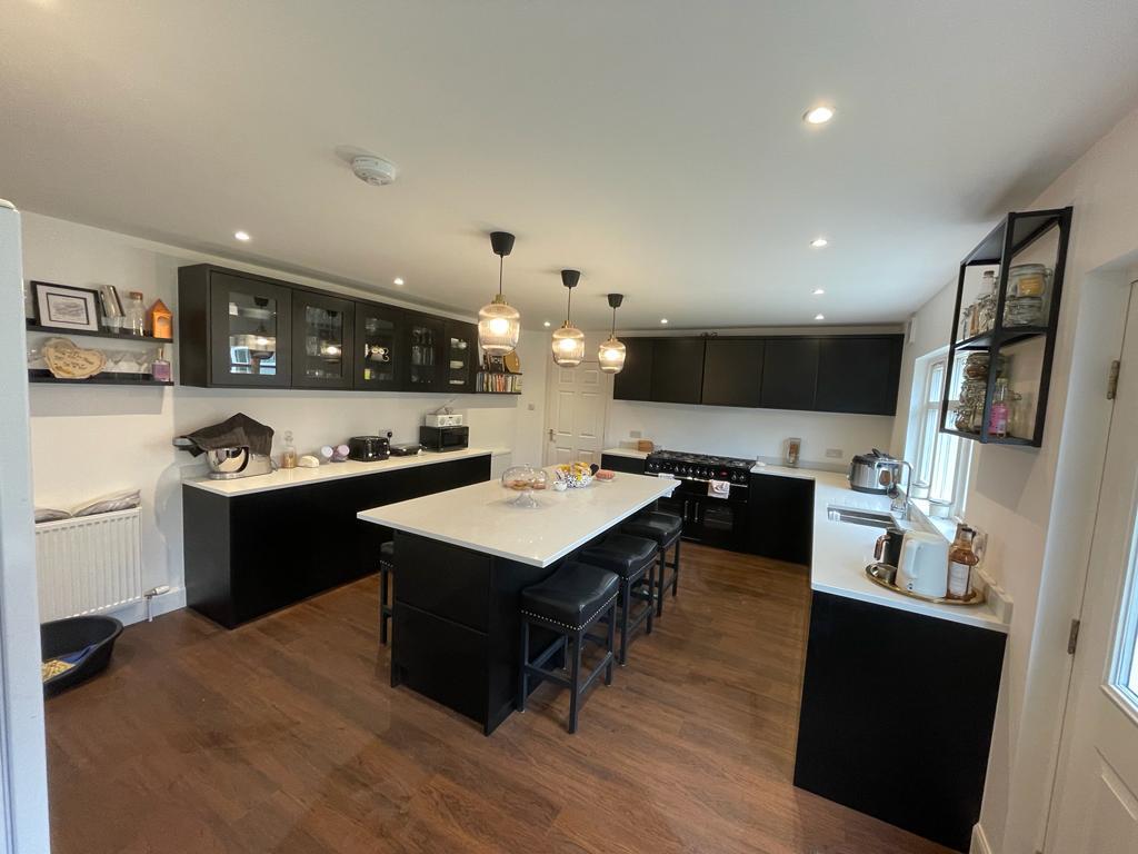 Black kitchen with white worktops and pendant lights