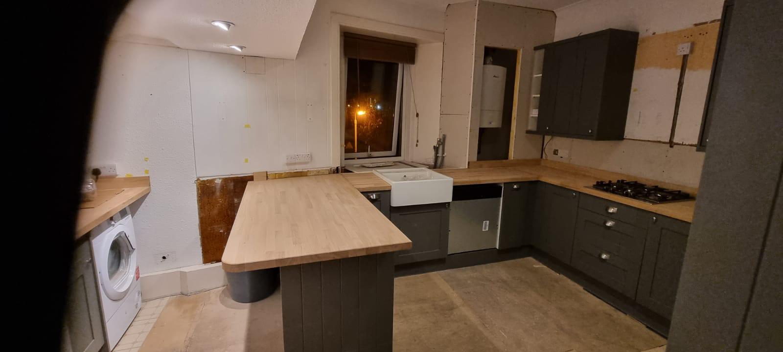 Dark grey kitchen with wooden breakfast bar