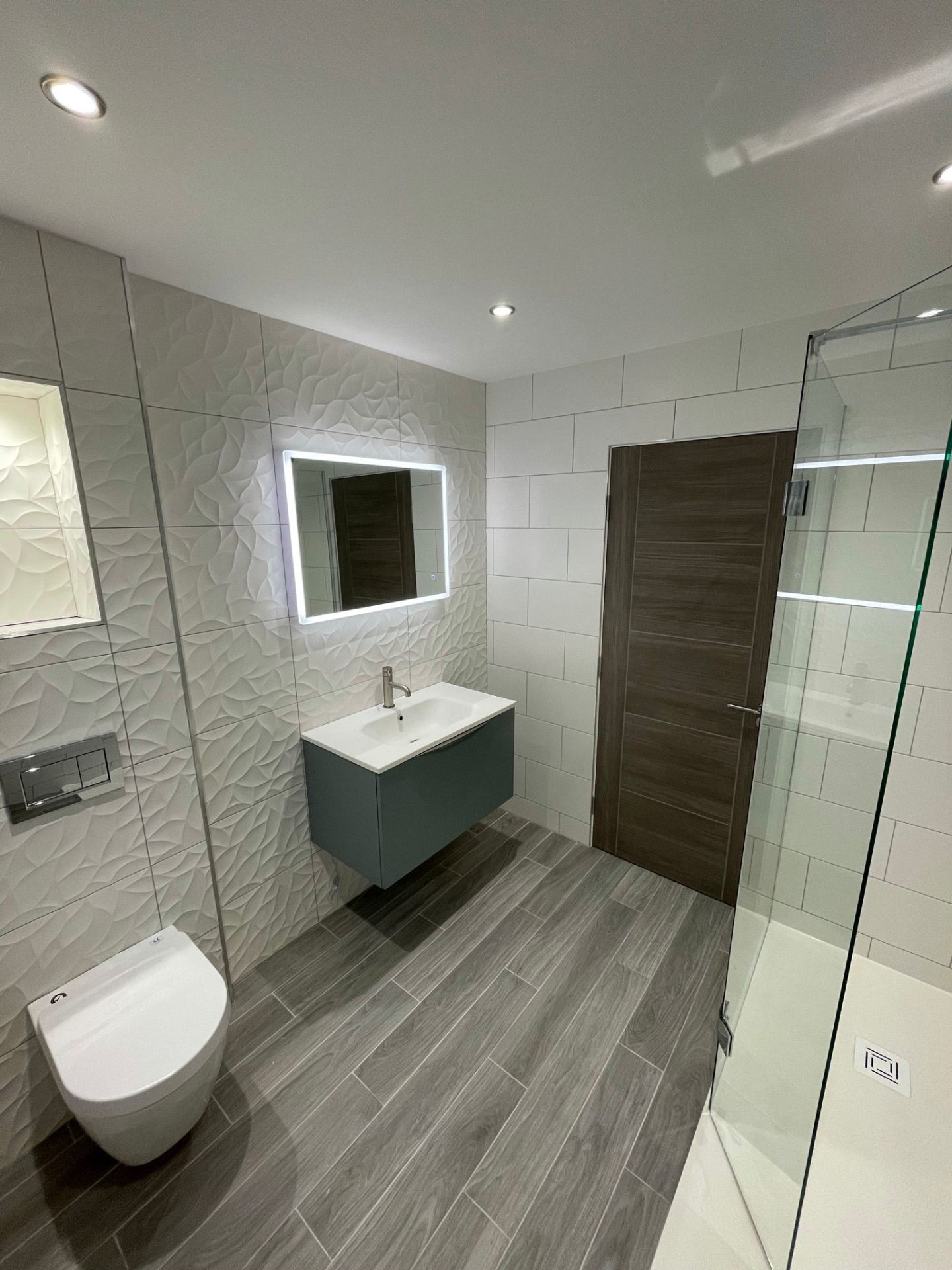 Modern bathroom with textured tiles and LED mirror in Perth